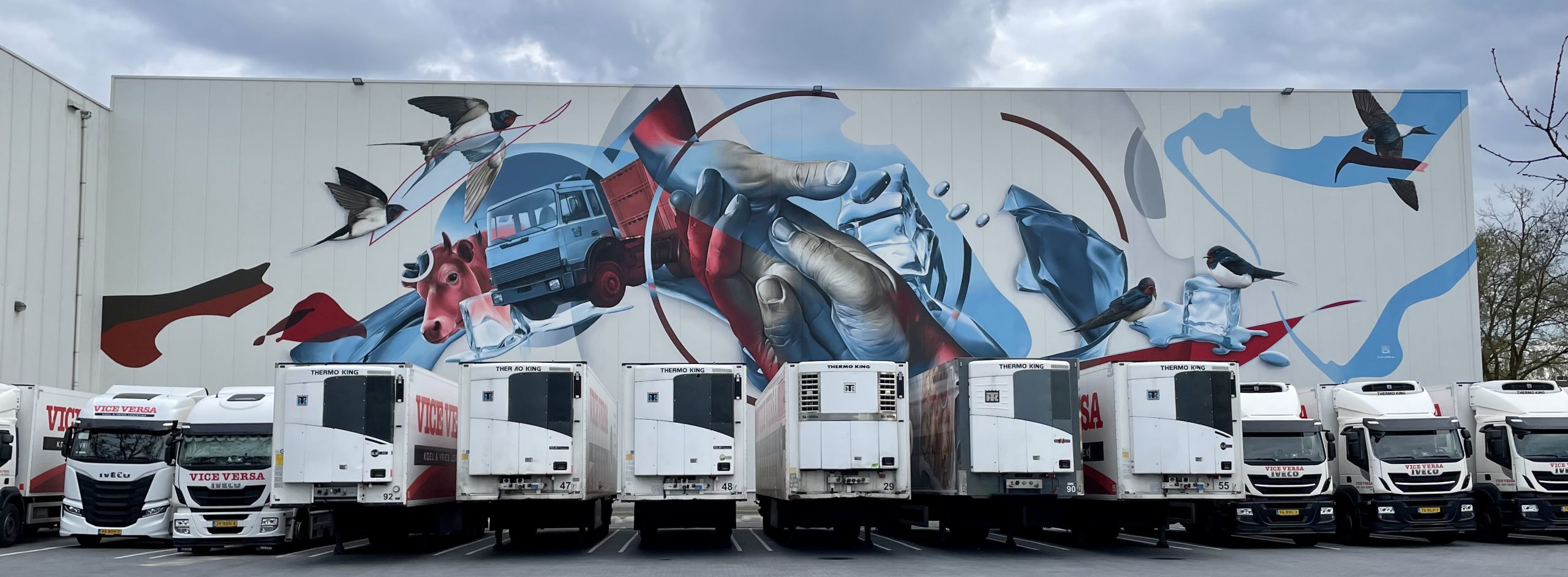 Muurschildering op koelcel van 18x55 meter in Oss – vijf vogels als familieportret door Marcus GOMAD Debie graffiti artiest gespecialiseerd in grote projecten